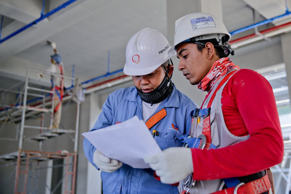 Two workers reviewing safety inspection documents at a construction site